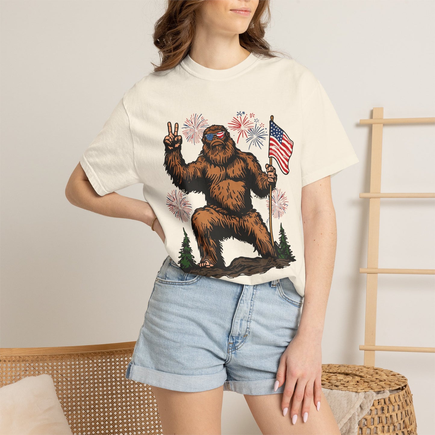 Patriotic Sasquatch Graphic T-Shirt — Bigfoot Holding American Flag, Fireworks 4th of July Tee
