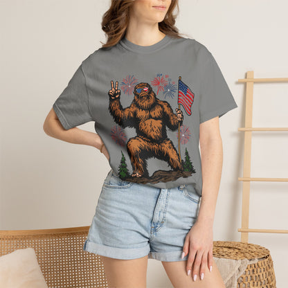 Patriotic Sasquatch Graphic T-Shirt — Bigfoot Holding American Flag, Fireworks 4th of July Tee