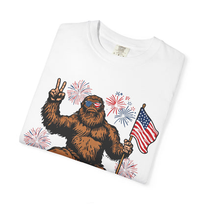 Patriotic Sasquatch Graphic T-Shirt — Bigfoot Holding American Flag, Fireworks 4th of July Tee