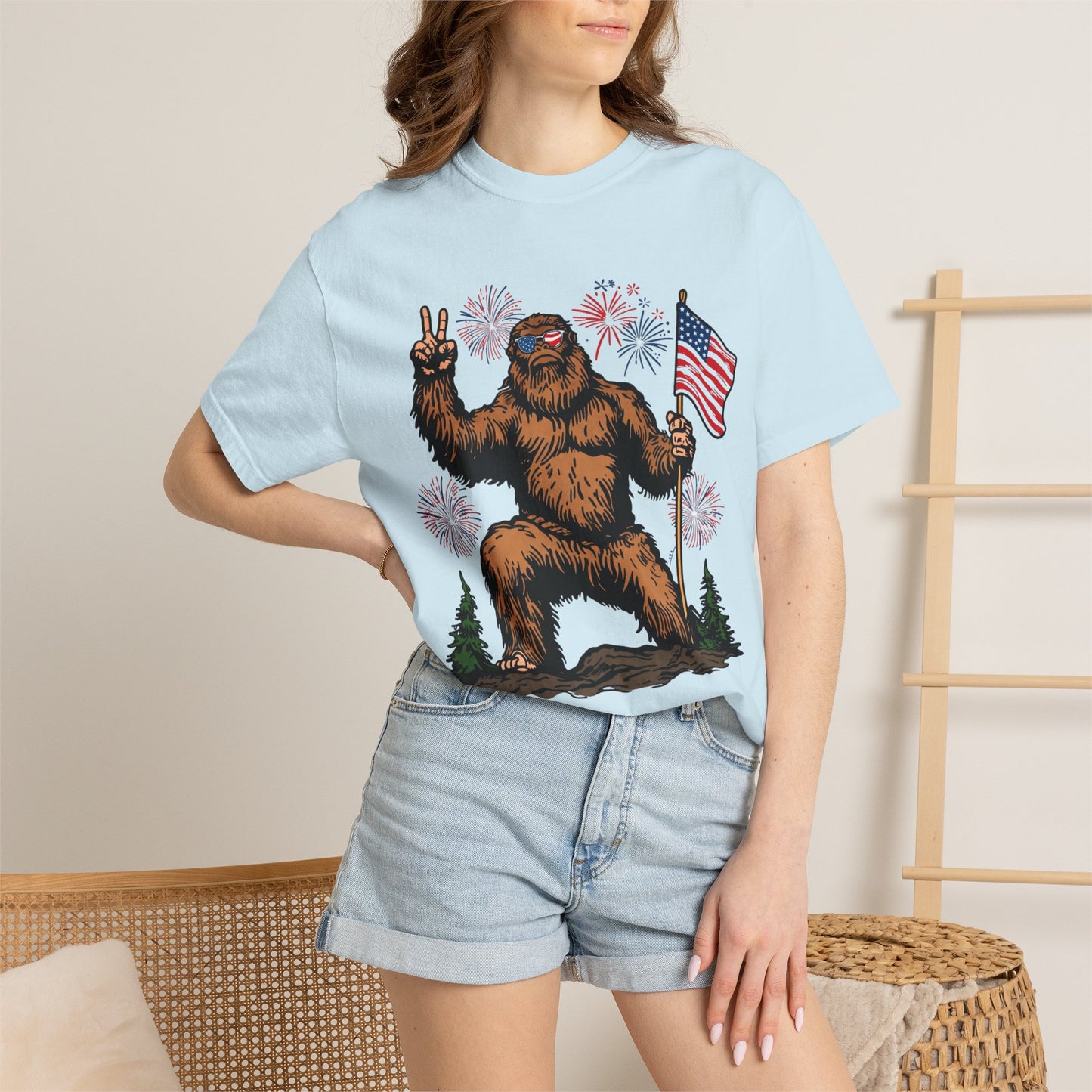 Patriotic Sasquatch Graphic T-Shirt — Bigfoot Holding American Flag, Fireworks 4th of July Tee