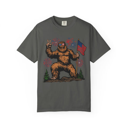 Patriotic Sasquatch Graphic T-Shirt — Bigfoot Holding American Flag, Fireworks 4th of July Tee