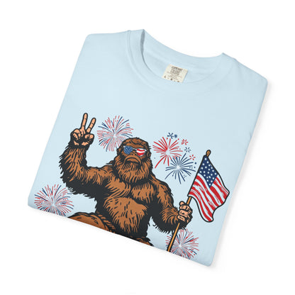 Patriotic Sasquatch Graphic T-Shirt — Bigfoot Holding American Flag, Fireworks 4th of July Tee