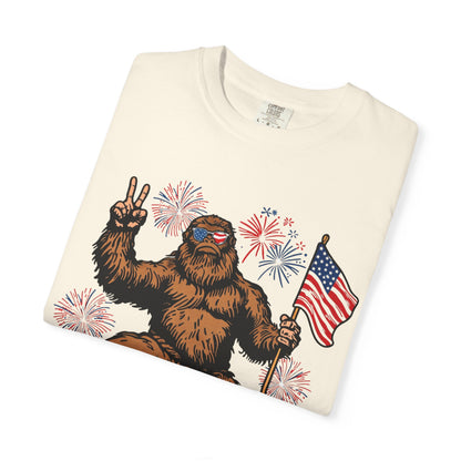 Patriotic Sasquatch Graphic T-Shirt — Bigfoot Holding American Flag, Fireworks 4th of July Tee