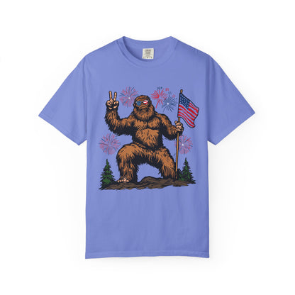 Patriotic Sasquatch Graphic T-Shirt — Bigfoot Holding American Flag, Fireworks 4th of July Tee