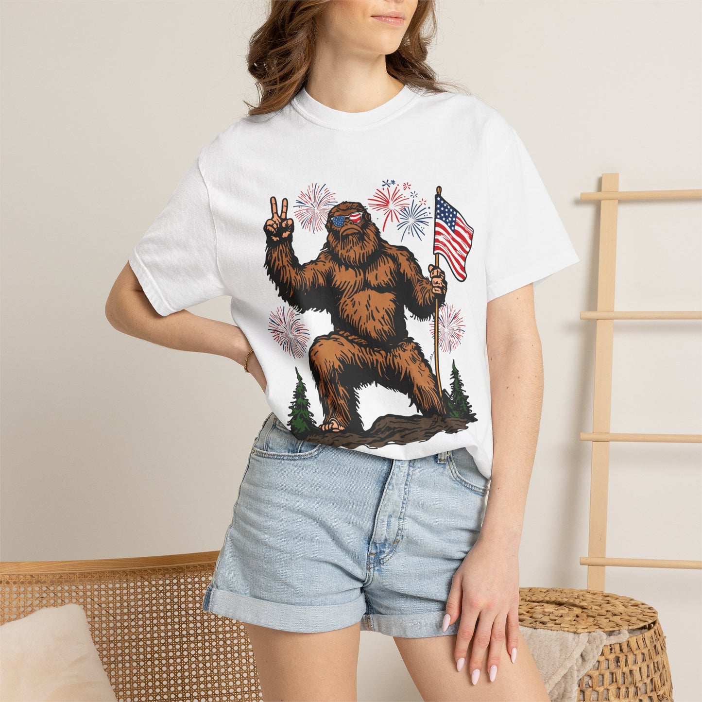 Patriotic Sasquatch Graphic T-Shirt — Bigfoot Holding American Flag, Fireworks 4th of July Tee