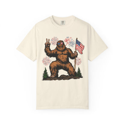 Patriotic Sasquatch Graphic T-Shirt — Bigfoot Holding American Flag, Fireworks 4th of July Tee
