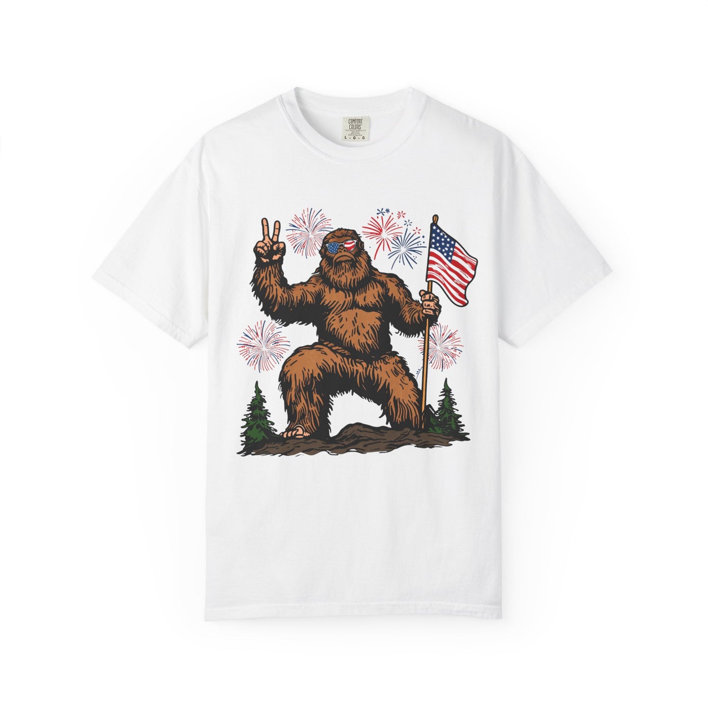 Patriotic Sasquatch Graphic T-Shirt — Bigfoot Holding American Flag, Fireworks 4th of July Tee