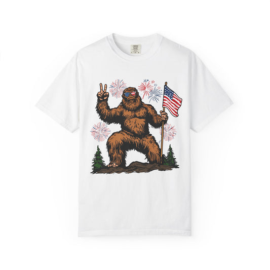 Patriotic Sasquatch Graphic T-Shirt — Bigfoot Holding American Flag, Fireworks 4th of July Tee