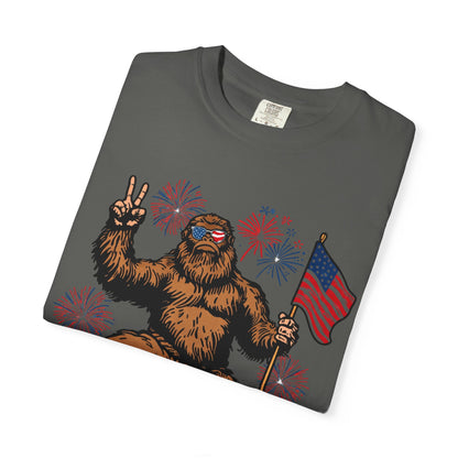 Patriotic Sasquatch Graphic T-Shirt — Bigfoot Holding American Flag, Fireworks 4th of July Tee